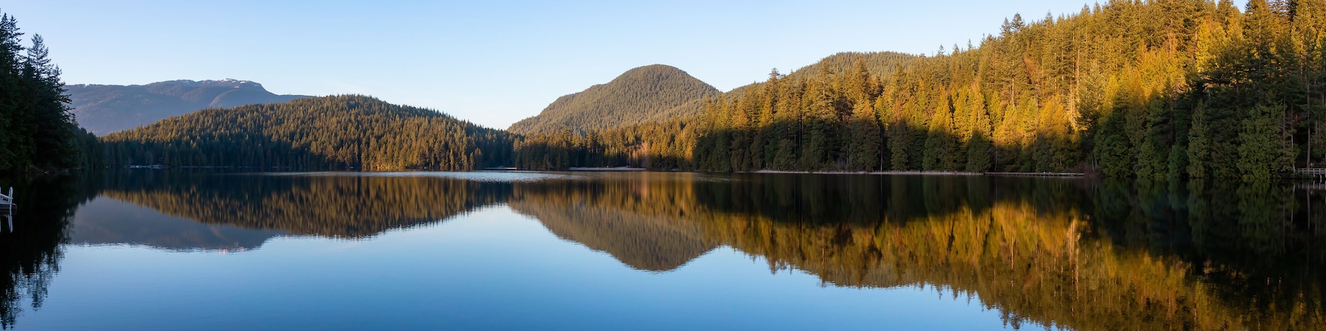Beautiful and Vibrant panoramic view of a lake surounded by Canadian Mountain Landscape during sunset. Taken in White Pine Beach, Port Moody, Vancouver, British Columbia, Canada. Panorama