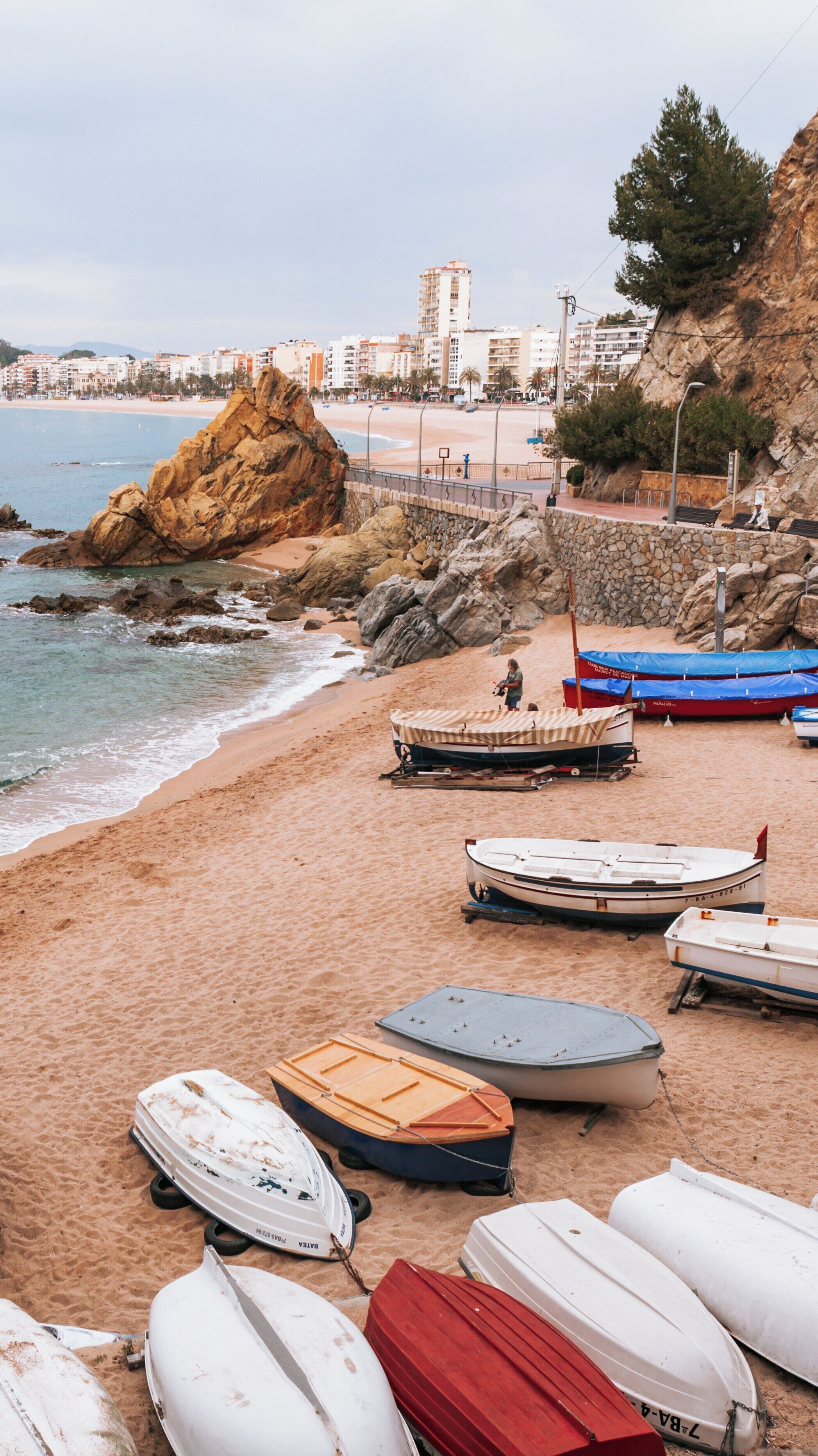 Enjoying the tranquil moments on Lloret de Mar Beach with boats and scenic views in Lloret Town Center, Catalonia, Spain