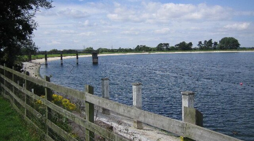Shustoke reservoir. The west end of Shustoke reservoir. This reservoir boasts a circular walk and a car park for walkers to use.