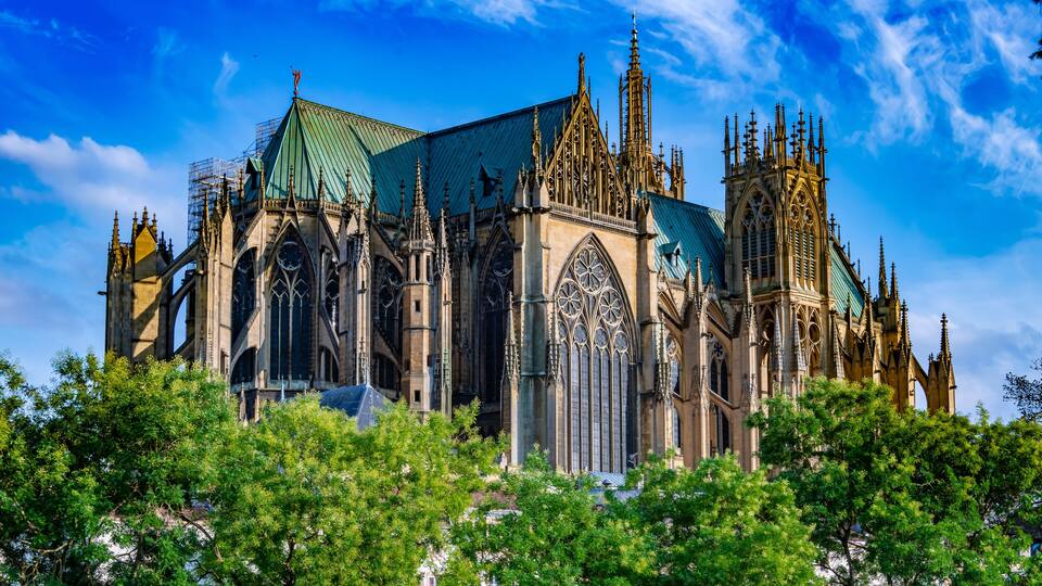 A Gothic cathedral with intricate spires and a green roof.