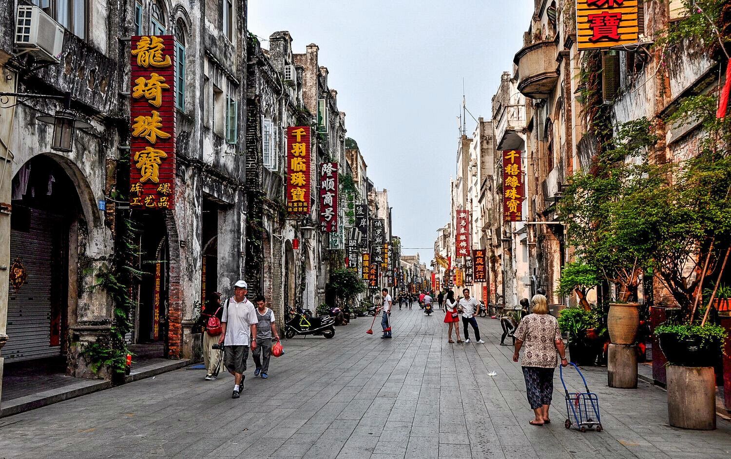 A historic street lined with traditional buildings and red signage.