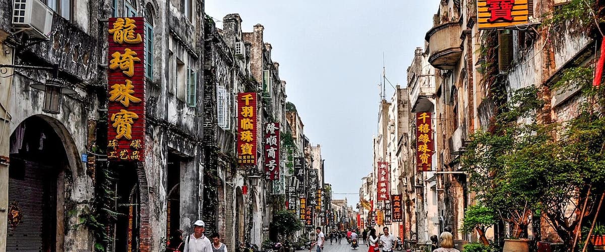A historic street lined with traditional buildings and red signage.