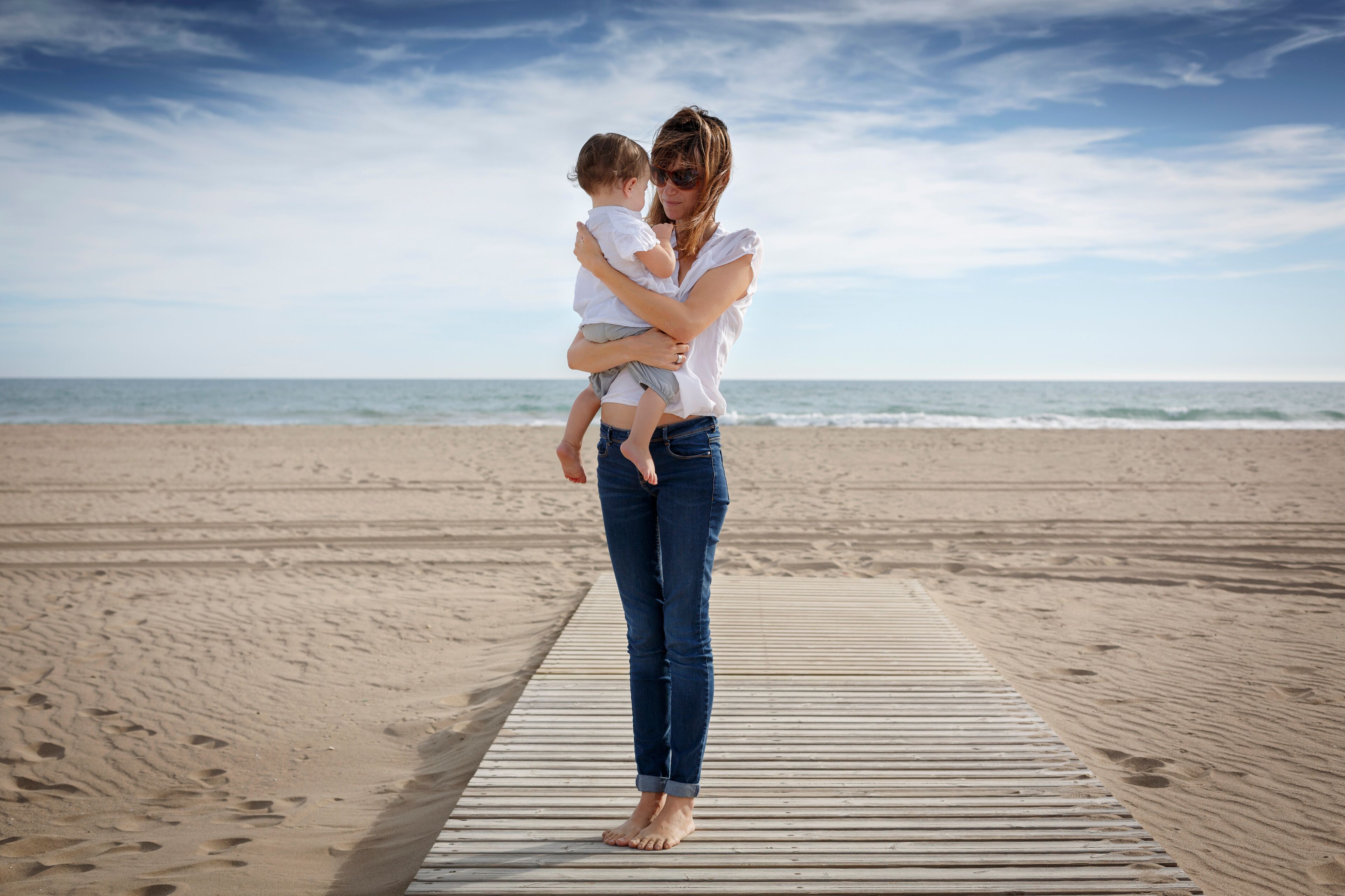 Mid adult woman and toddler daughter on beach, Castelldefels, Catalonia, Spain