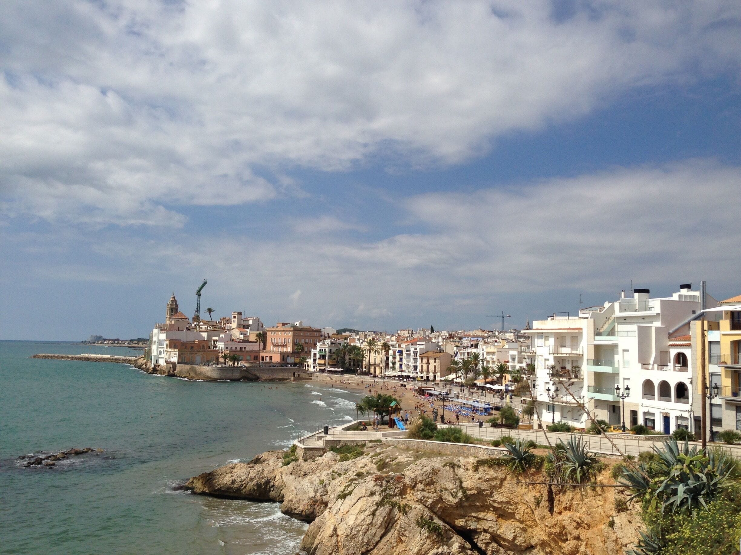 Sitges' rocky coastline with pretty pastel-colored houses