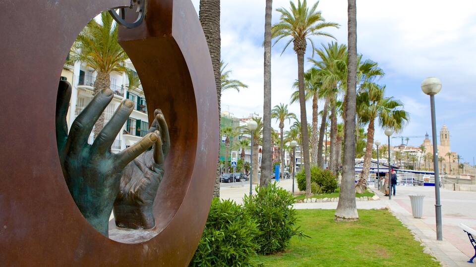 A sculpture of a hand holding a key, palm trees, and a coastal cityscape.
