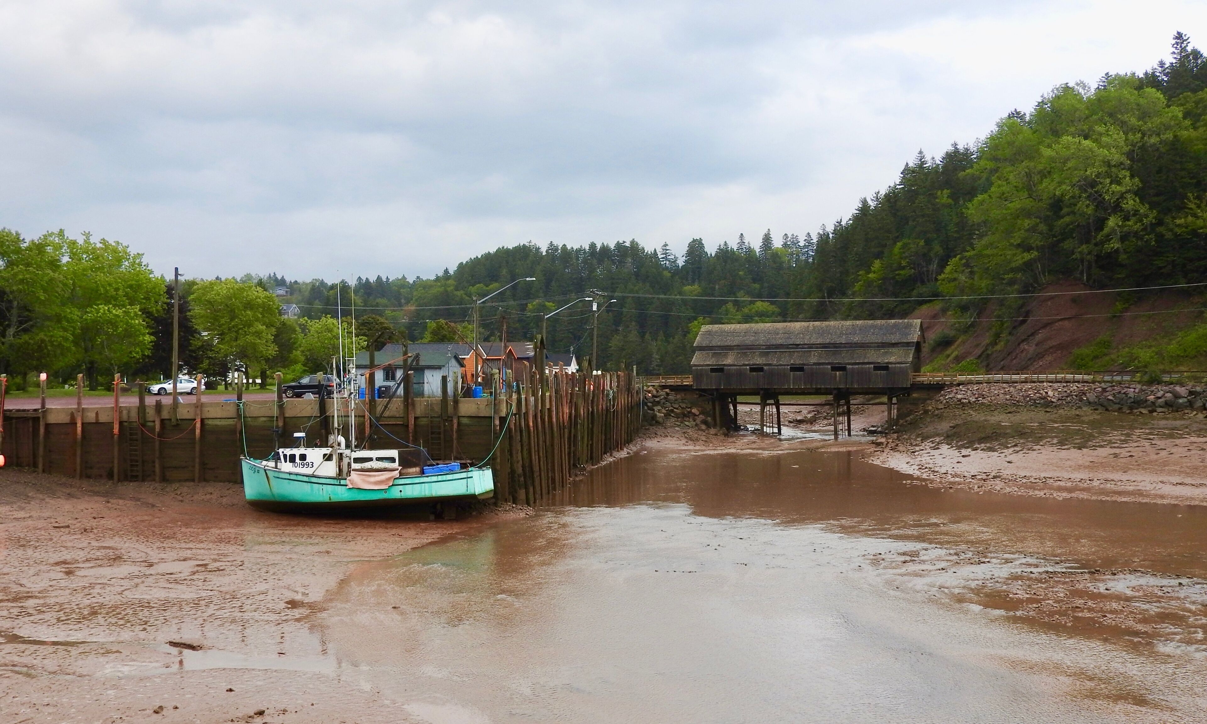 St. Martins covered bridge boat St. Martins is  a place of tidal wonder at the  heart of the Bay of Fundy.  Life here is governed by the rhythm of the world's highest tides.  A colourful fleet of fishing boats wait in the Bay for the high tide to rise and fill the empty harbour with water so that they can unload their catch.

#LikeALocal
