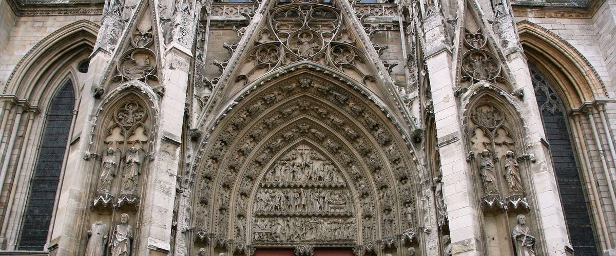 A Gothic cathedral facade with intricate stone carvings and a large central doorway.