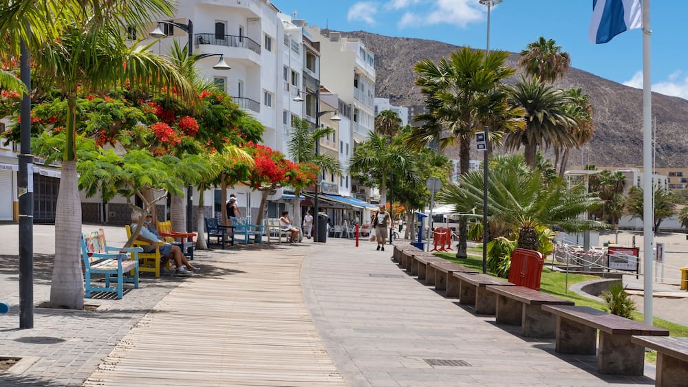Few residents resting or walking on the usually very busy promenade in front of Playa Los Cristianos on Av. Juan Alfonso Batista in Los Cristianos, Arona, Tenerife, Canary Islands, Spain