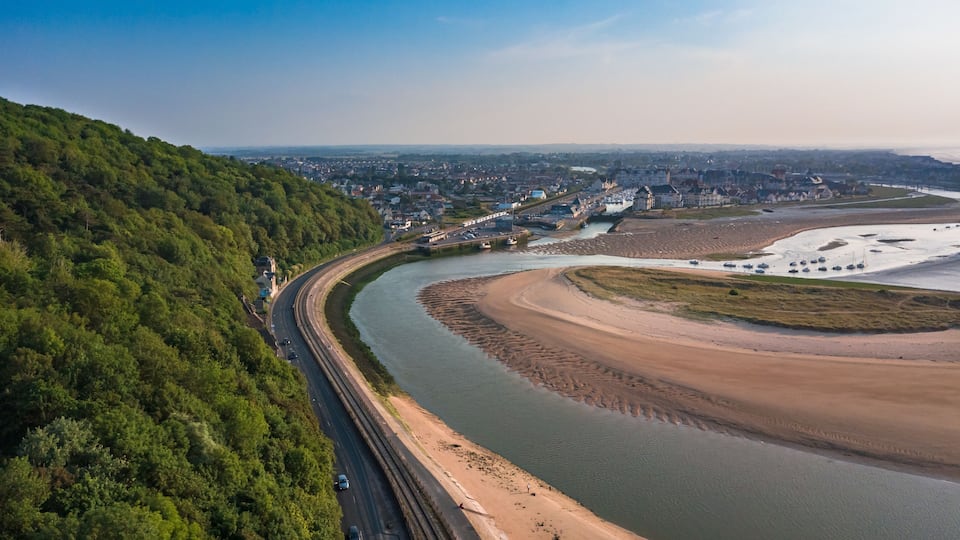A river curving through a town with a railway track alongside.