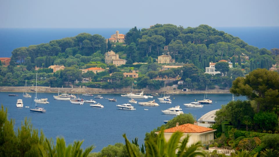A coastal town with a hilltop church, boats on the water, and lush greenery.