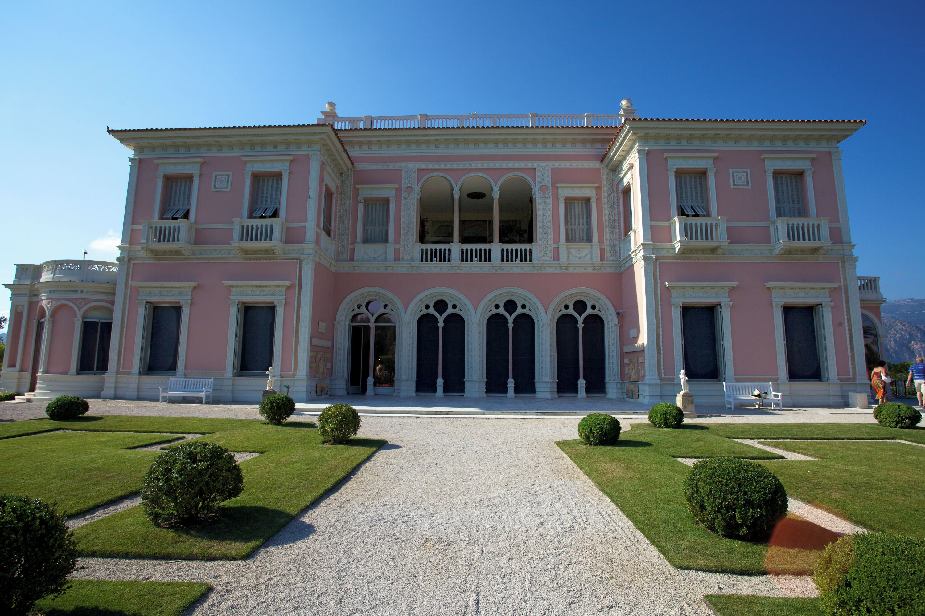 A pink building with arched windows and a central courtyard.