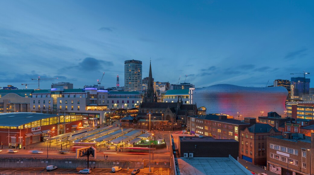 A cityscape at dusk with a distinctive spherical building and a prominent church spire.