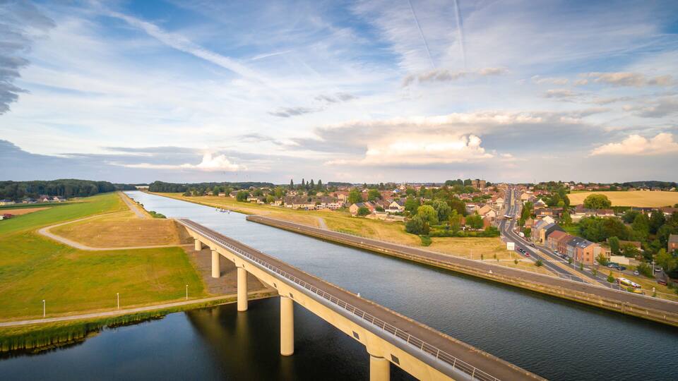A river with a bridge, a town, and fields.