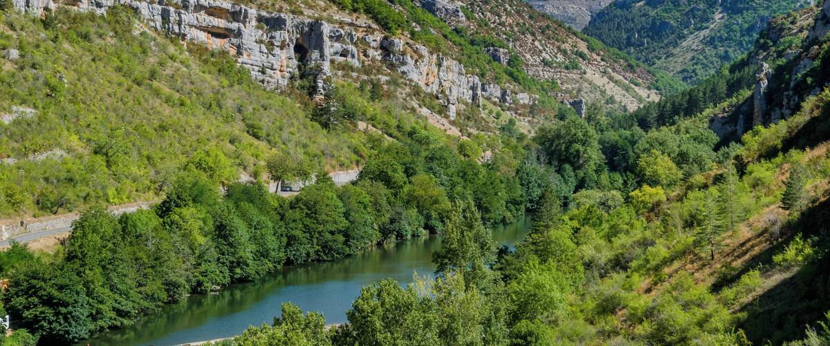 A river winding through a valley with rocky cliffs and dense greenery.