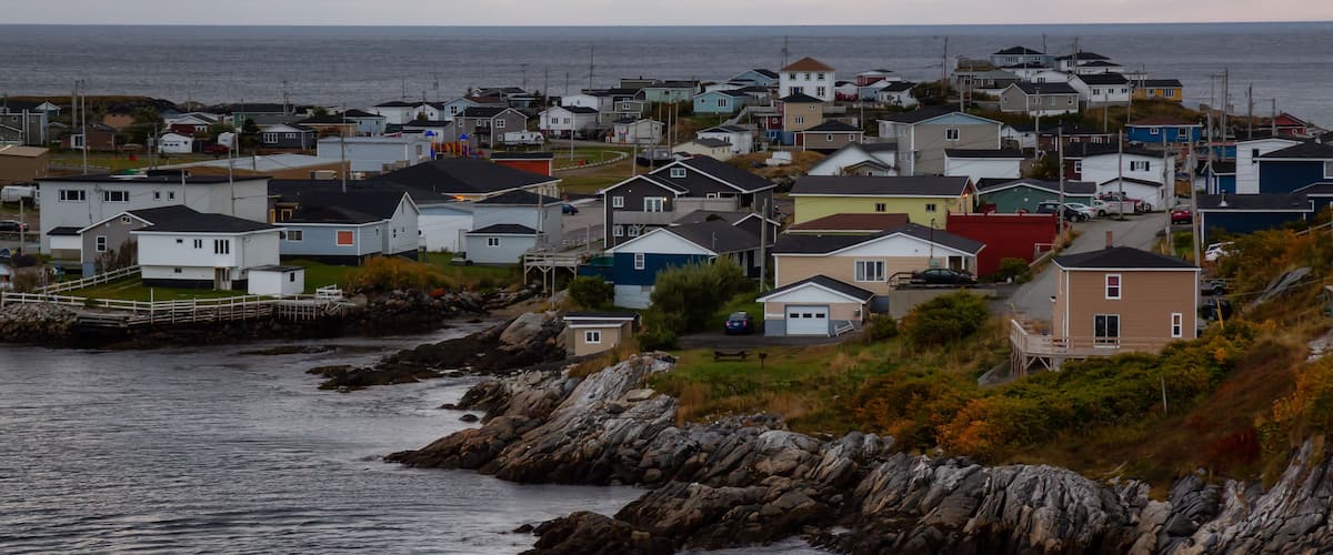 Homes in a little town on the rocky Atlantic Ocean Coast during a cloudy sunset. Taken in Channel-Port aux Basques, Newfoundland, Canada.