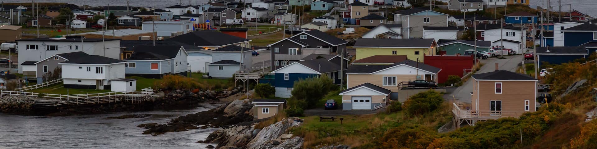 Homes in a little town on the rocky Atlantic Ocean Coast during a cloudy sunset. Taken in Channel-Port aux Basques, Newfoundland, Canada.