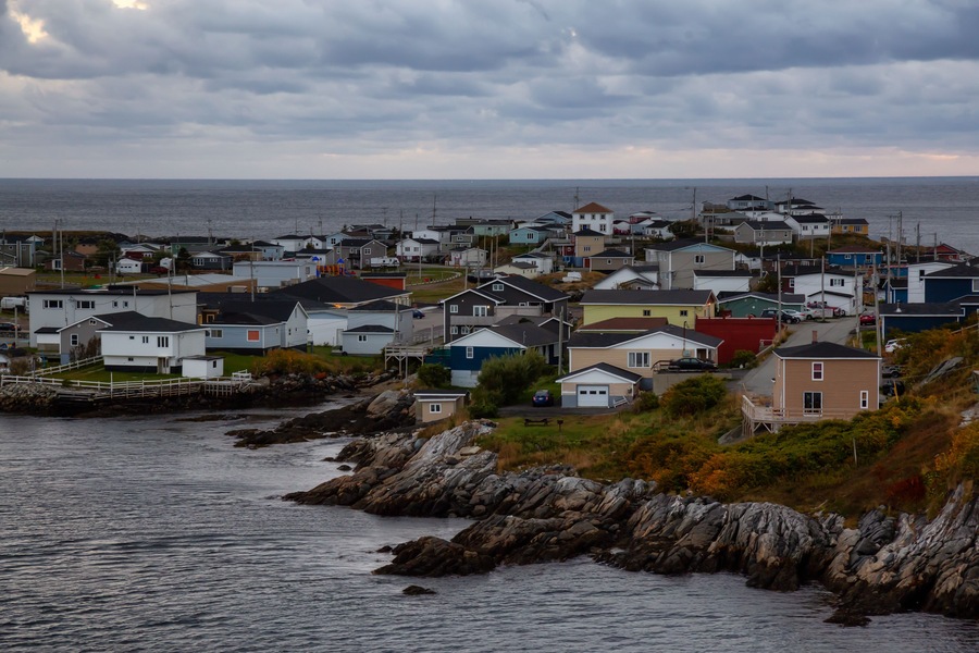 Homes in a little town on the rocky Atlantic Ocean Coast during a cloudy sunset. Taken in Channel-Port aux Basques, Newfoundland, Canada.