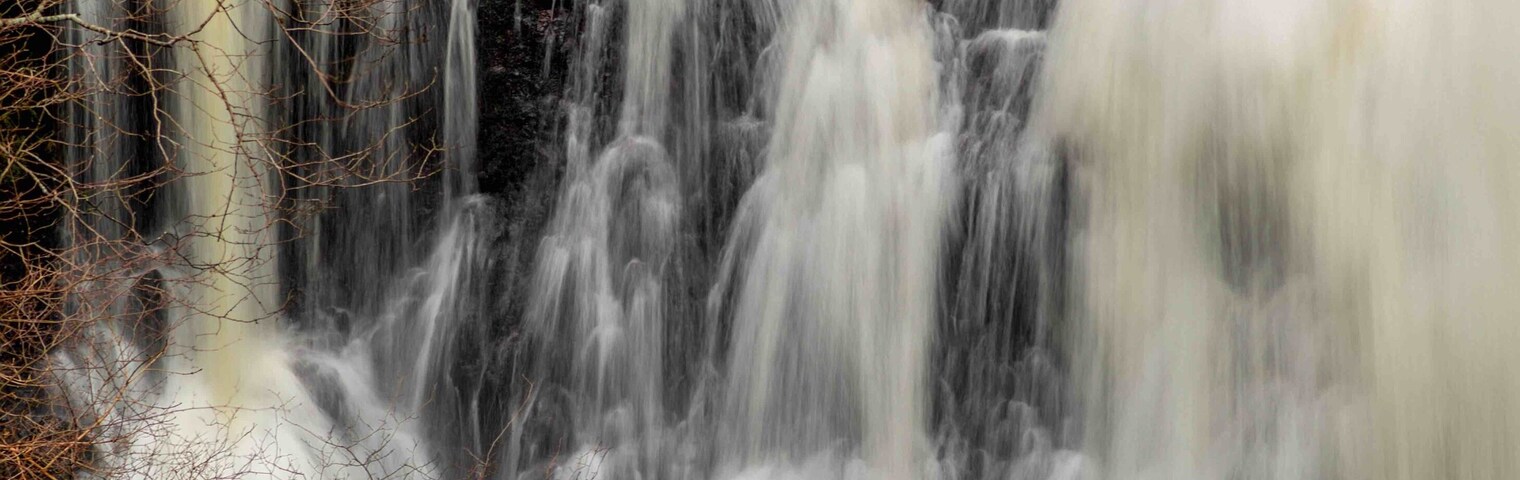 A multi-tiered waterfall with cascading water over rocks.