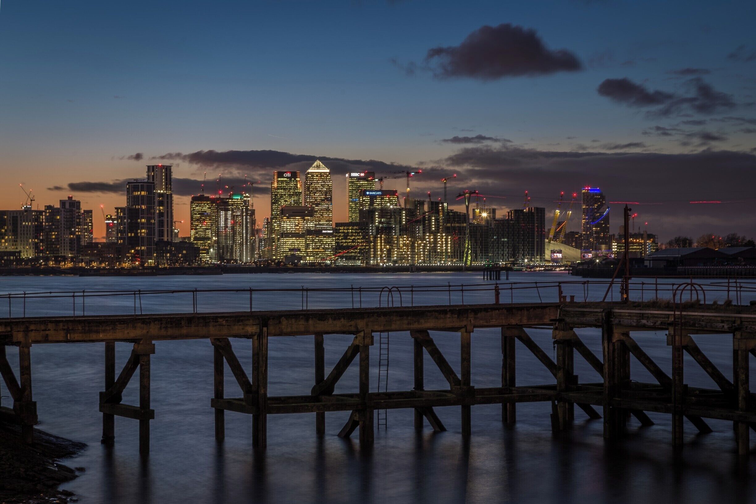 It was a chilly walk tonight in London, but well worth it.

I had never been to the Thames Barrier and was inspired to go there by a couple of photos I saw on Trover.

I will post a couple of the barrier itself at some point.  This one was taken from the Thames River path just west of the barrier looking towards the Greenwich Peninsula and Canary Wharf.

You will recognise the Canary Wharf towers in the background.  Also the O2 arena on the right.  The red "lines" on the far right and going down in the middle of the frame are actually the moving cable cars (long exposure) from the Emirates Air Line.

Nice spot! 