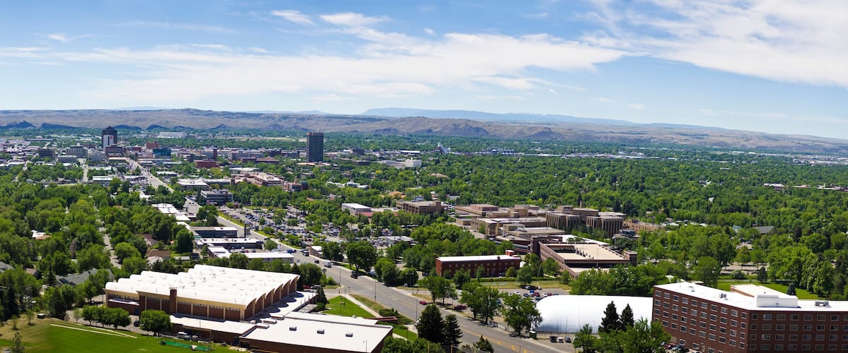 A cityscape with a large industrial area, a central business district, and surrounding green hills.