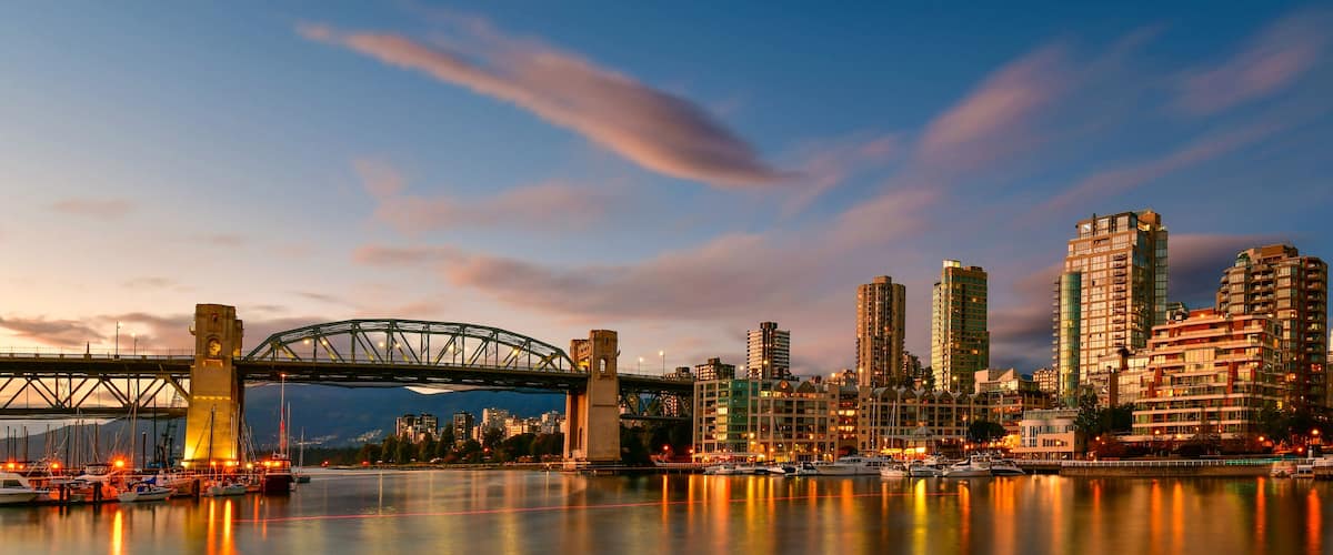 A city skyline with a prominent bridge, high-rise buildings, and a marina with boats.