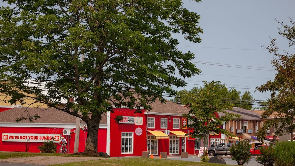 A red building with a sign for 'George Peters' and a tree in front.