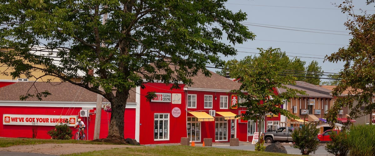 A red building with a sign for 'George Peters' and a tree in front.