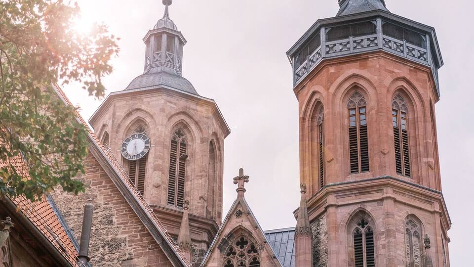 A church with a clock tower and a weather vane.
