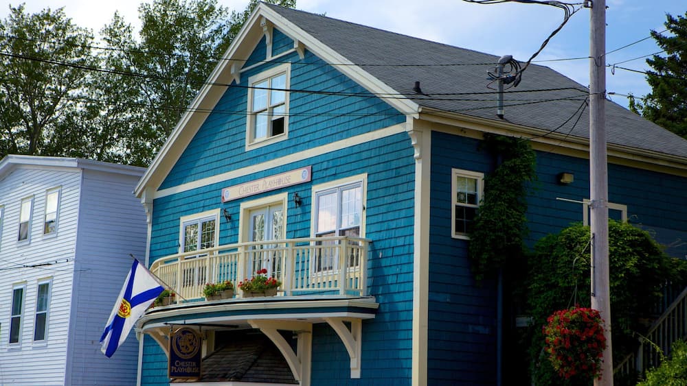 Une maison bleue avec un porche blanc et un drapeau.