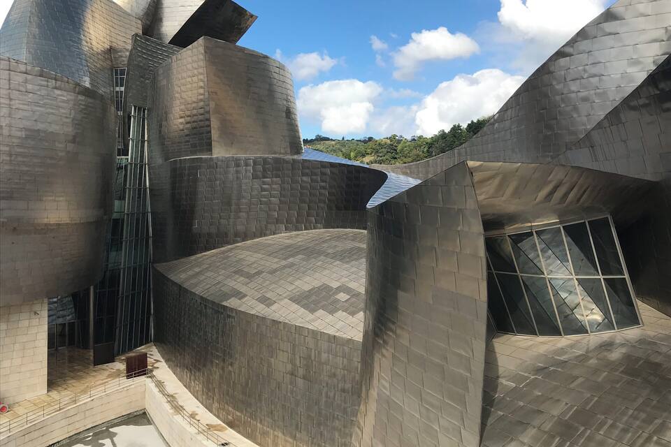 A modern architectural structure with metallic surfaces and angular shapes.