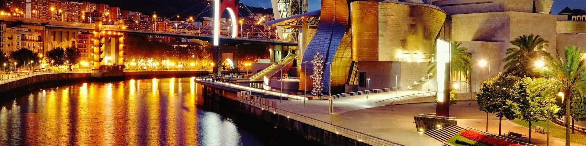 What an amazing piece of architecture, art museum and location!!!
It is simply gorgeous from any angle. During the day, the natural sunlight creates unique reflections and shadows on its curvaceous and shiny metallic surface. At night, that role is taken over by man-made lighting creating similarly spectacular reflections on its surface.
Found this vantage point on a nearby wooden bridge overlooking the building and the river. On this autumn day in September, the skies only turned dark after 9pm despite it being a cloudy and slightly wet day.