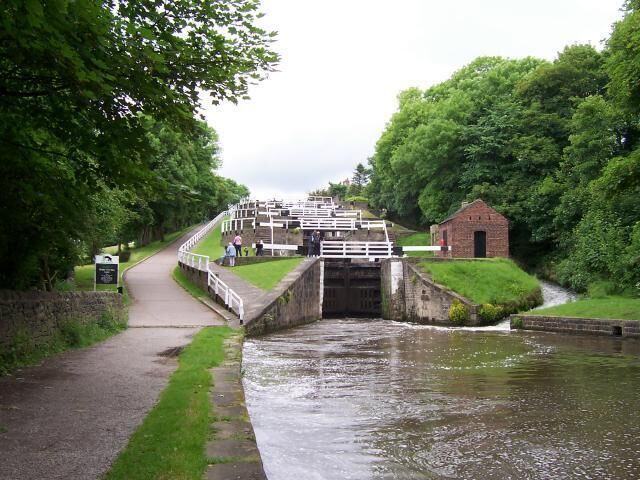 A canal with a lock and a small brick building.