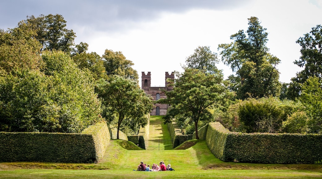 Family having picnic with Belvedere Tower in distance, Claremont Landscape Garden, Esher, Surrey, UK
