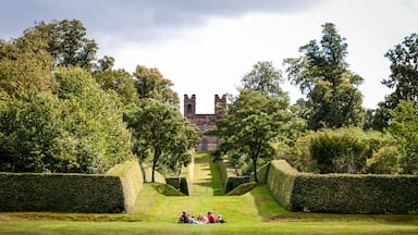 Family having picnic with Belvedere Tower in distance, Claremont Landscape Garden, Esher, Surrey, UK