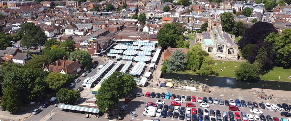 An aerial view of a town with a river, a church, and a market area.