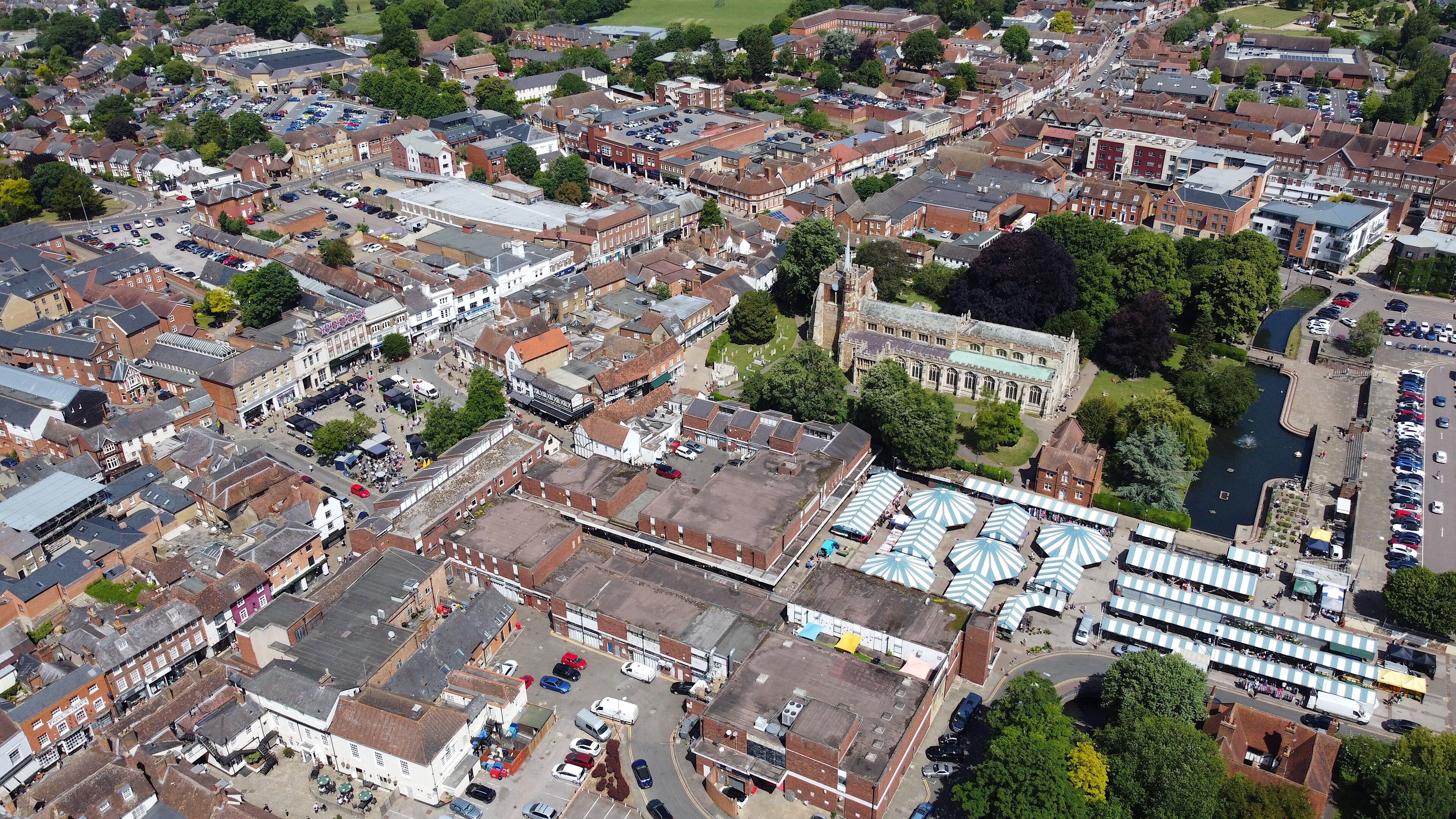 An aerial view of a historic town with narrow streets, a prominent church, and a river.