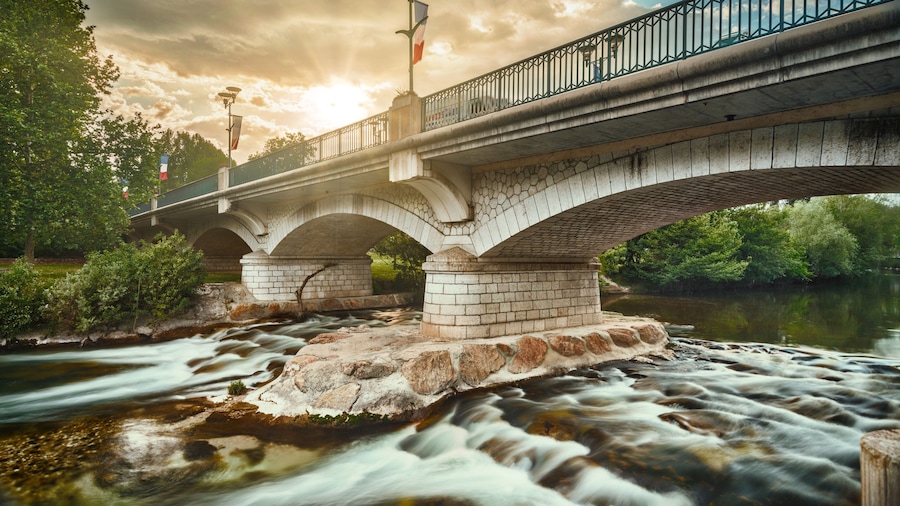 Un puente de piedra con arcos sobre un río caudaloso.