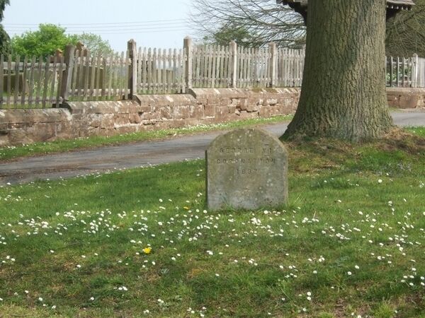 Not a gravestone! Standing just outside the churchyard the stone commemorates the coronation of George VI in 1937.