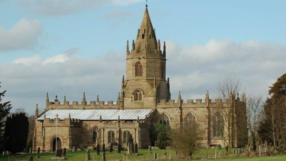 A historic church with a tall spire and a large bell tower.