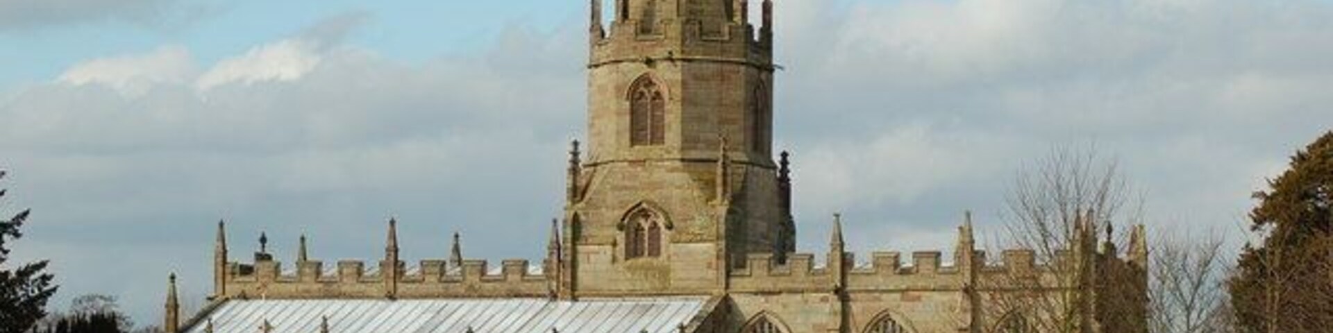 Una iglesia histórica con un campanario alto y una gran torre de campanas.