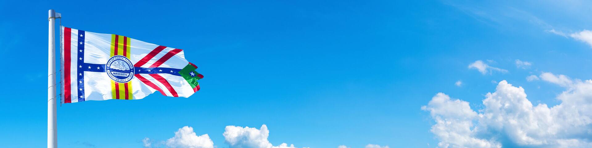 Tampa, USA - flag waving on a blue sky in beautiful clouds - Horizontal banner