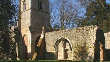 Uma igreja de pedra histórica com uma torre de sino e porta em arco.