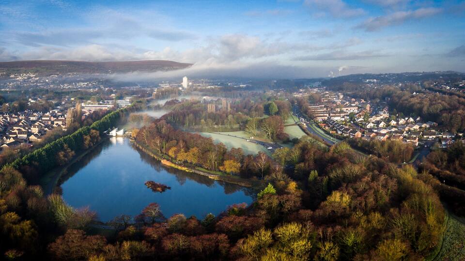 A river winding through a town surrounded by autumn foliage.