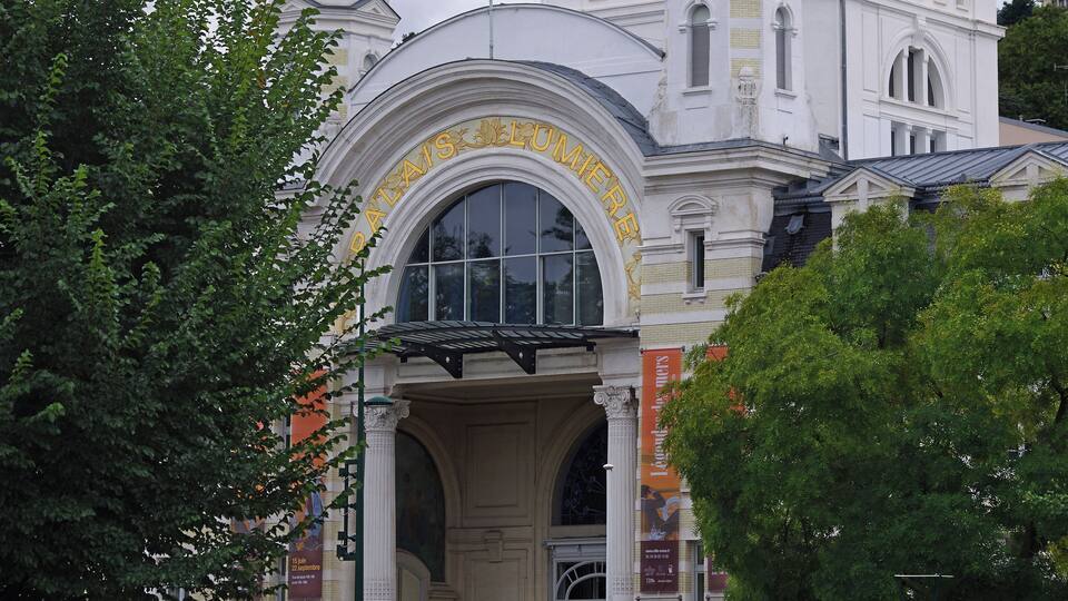 A historic building with ornate architecture, including a large arched entrance and columns.