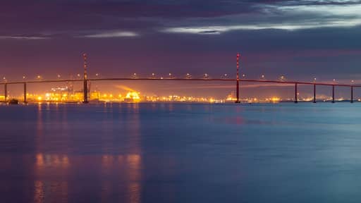 Un ponte che attraversa un corso d'acqua, con le luci della città sullo sfondo.