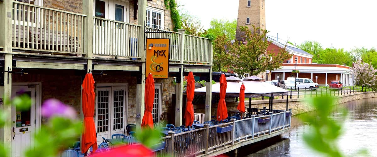 A riverside restaurant with outdoor seating and a sign reading "Mex Co."