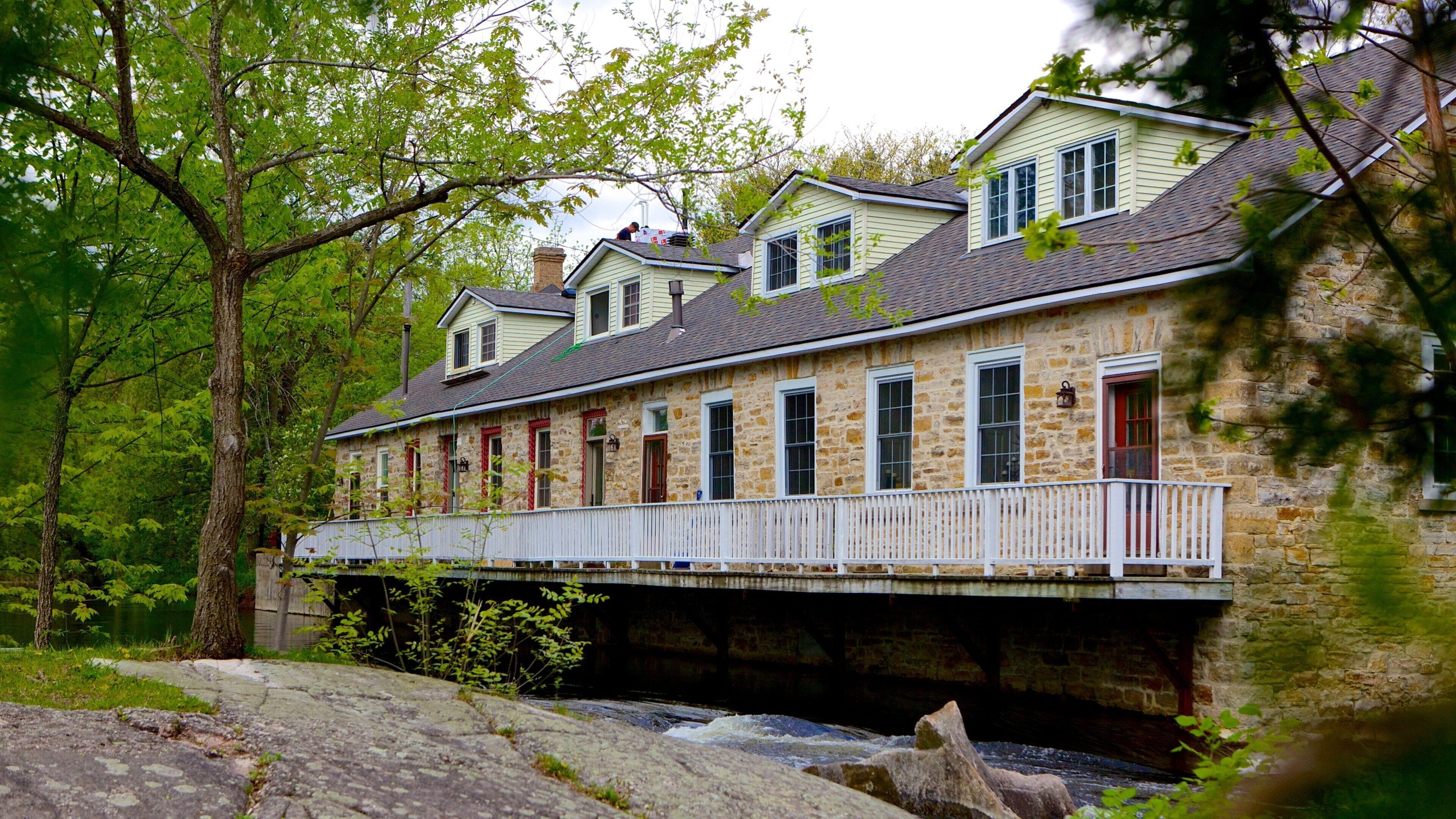 A stone building with a wooden deck over a river.