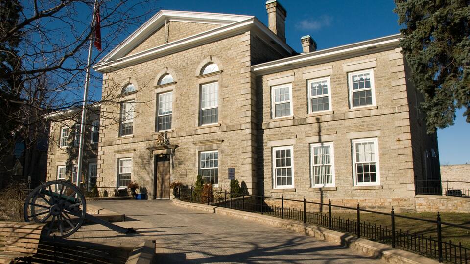 A historic stone building with arched windows and a flagpole.