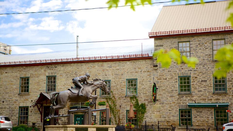 A stone building with a statue of a man on a horse in front.