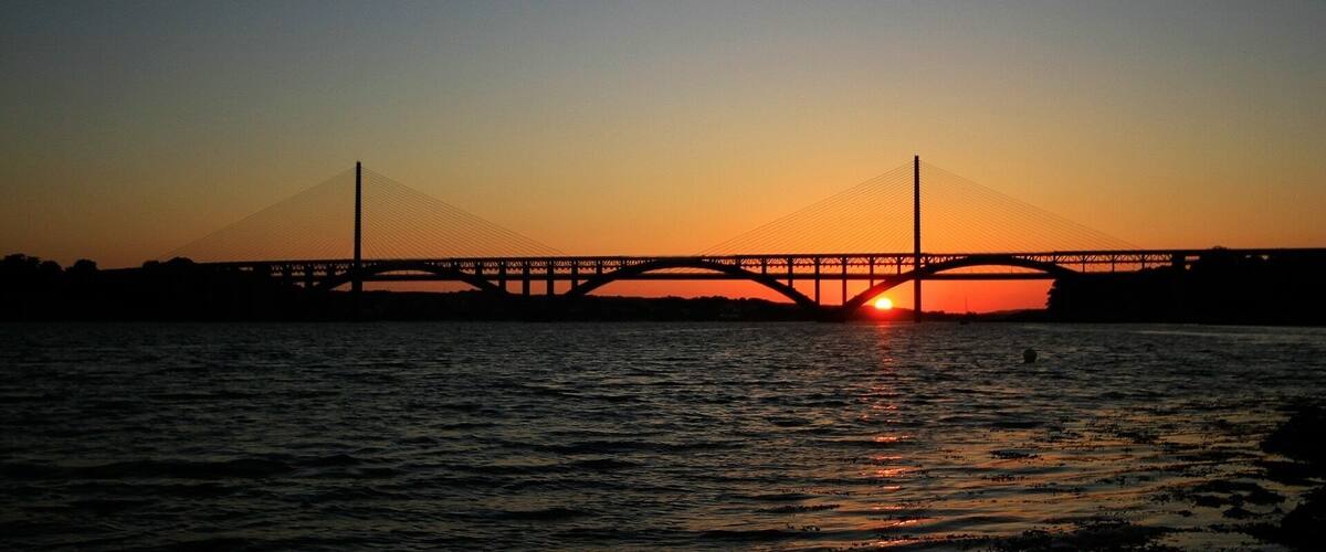 A bridge at sunset with the sun setting behind it.